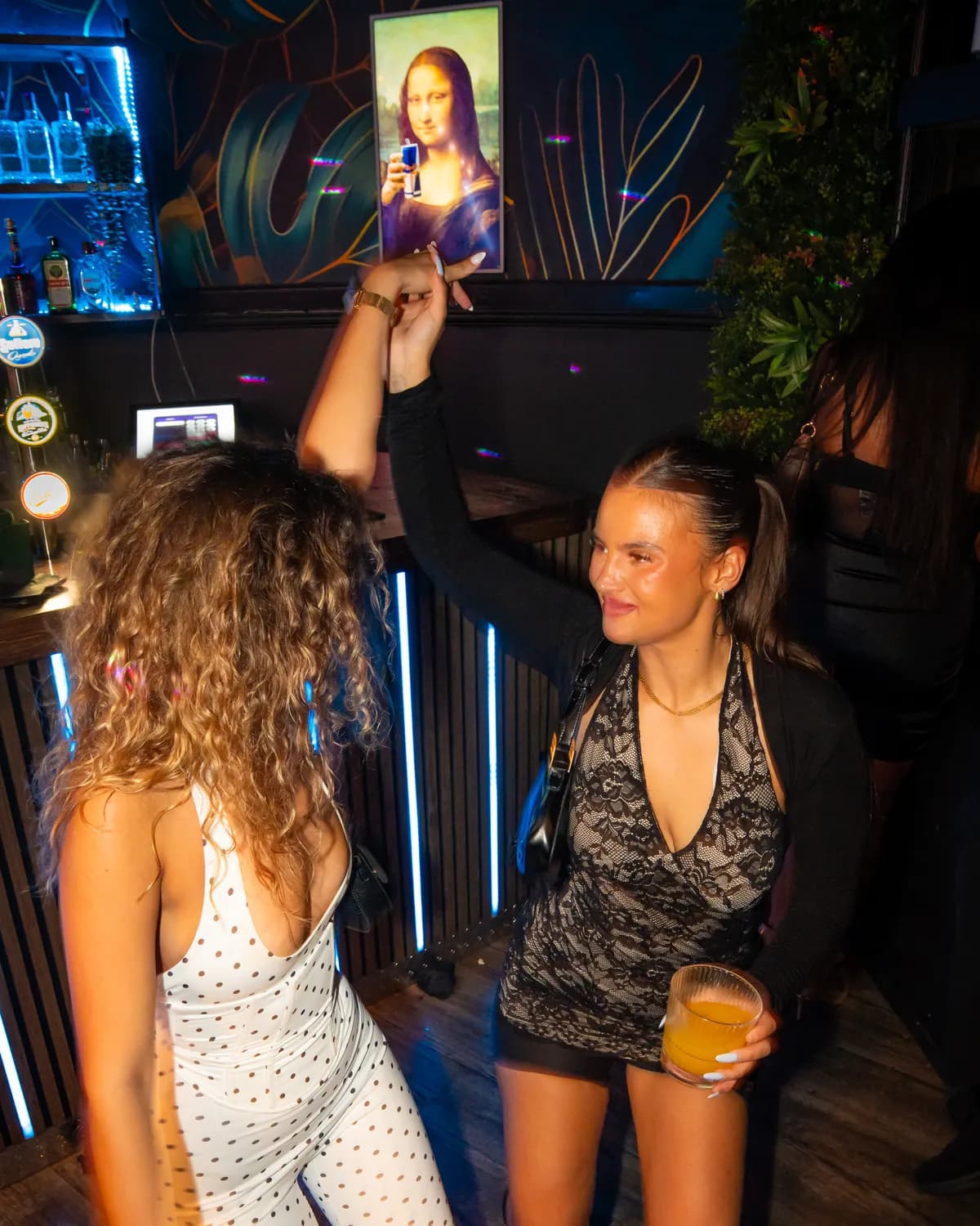 Gäster dansar med armarna i luften vid baren