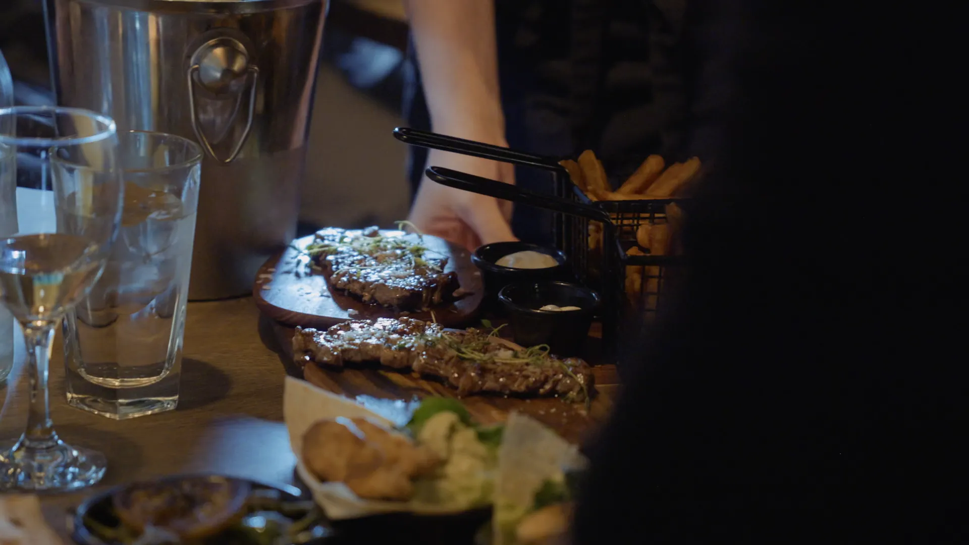 Kött, pommes och glas på ett dukat bord