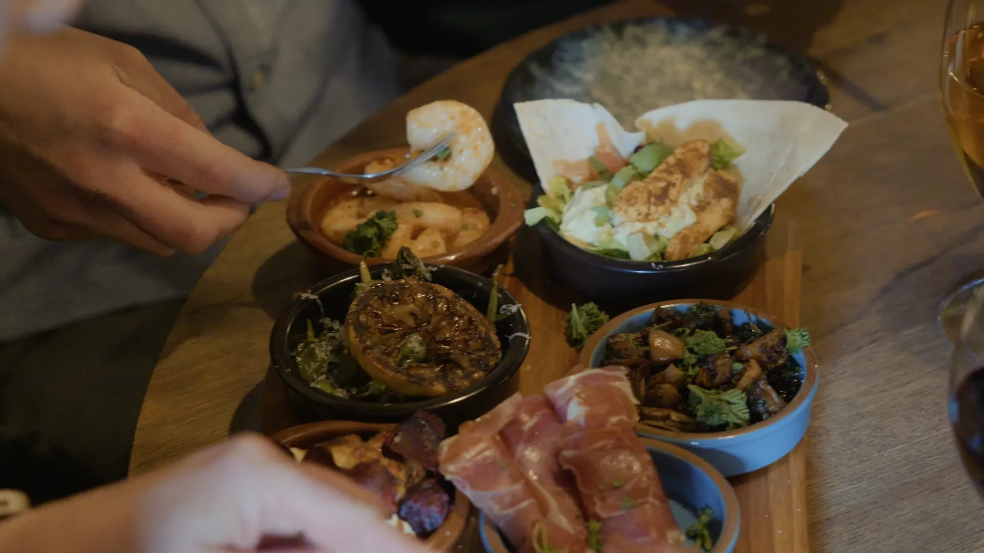 Gäster som delar tapas vid ett träbord