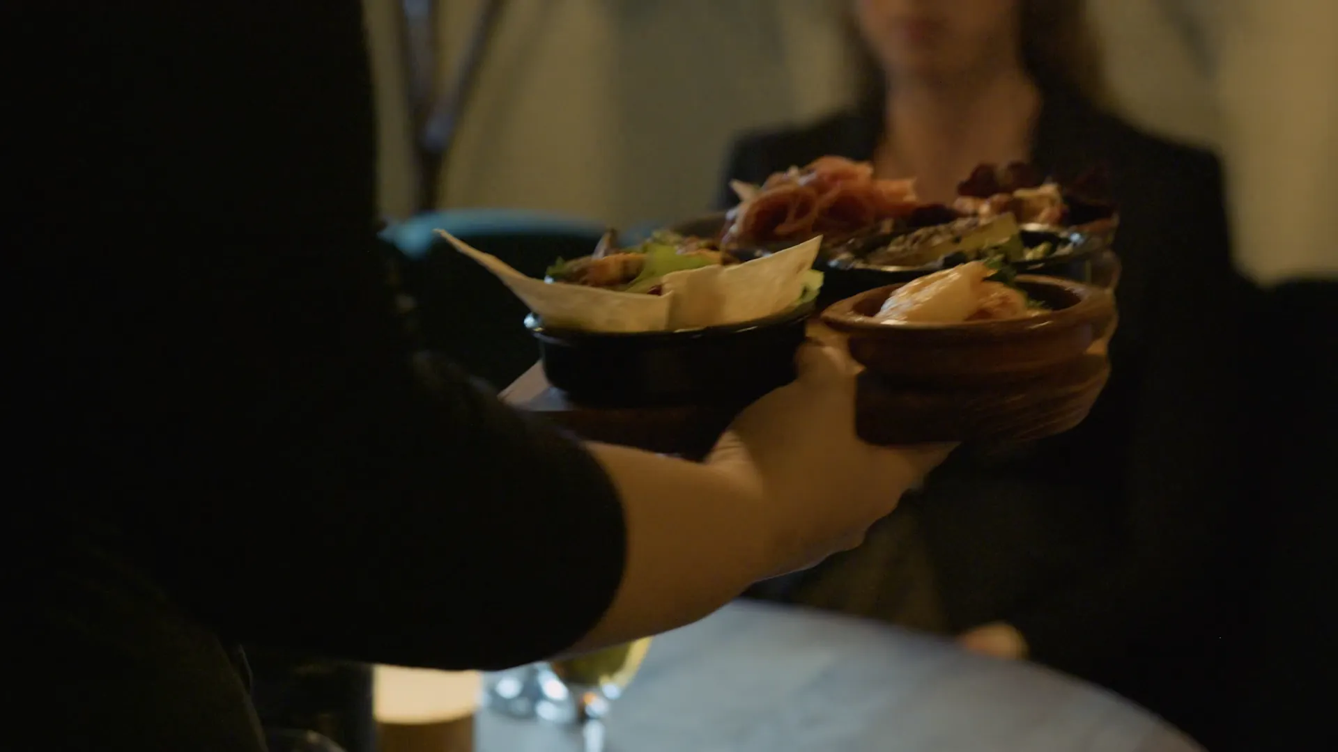 En servitör bär ut tapas i skålar