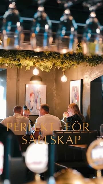 Baren med hängande glas och grönska, gäster som sitter och äter
