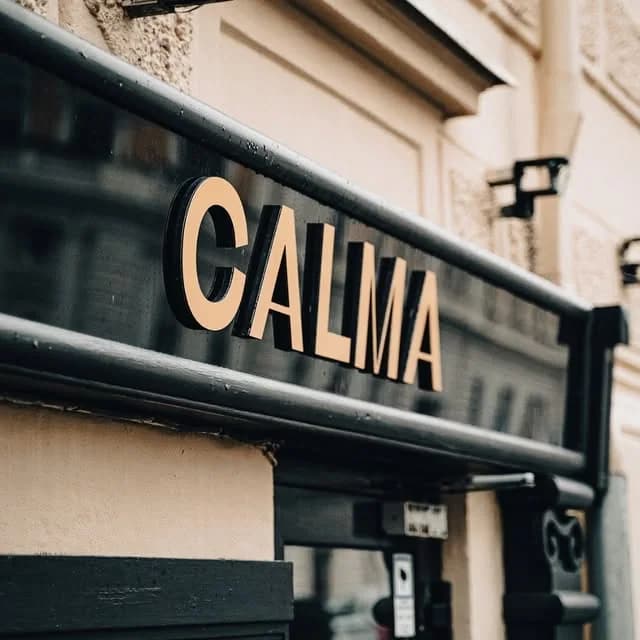 Calma-skylten i guld och svart på husfasaden