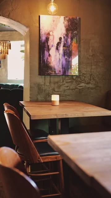 Matsalen med lysande målning, träbord och lampa
