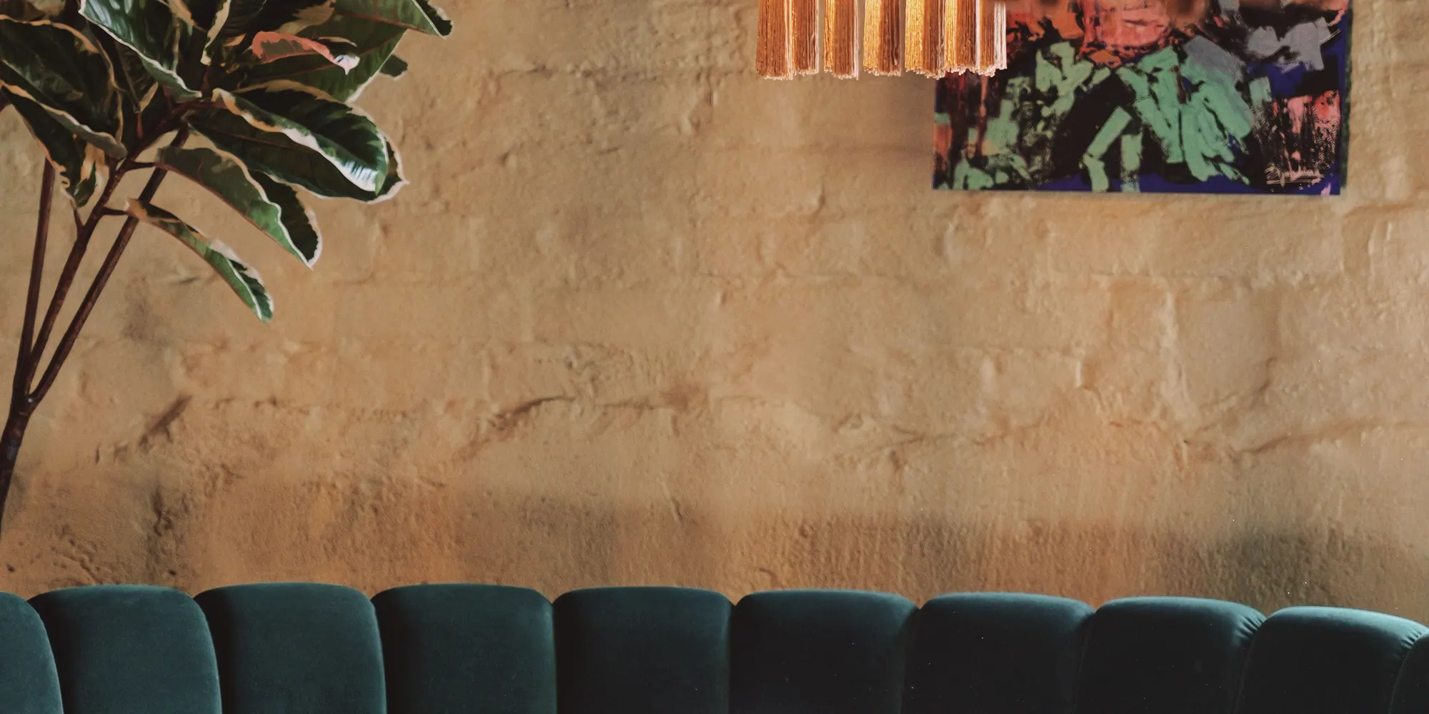 Kopparljuskronan över de gröna sofforna vid fönstret