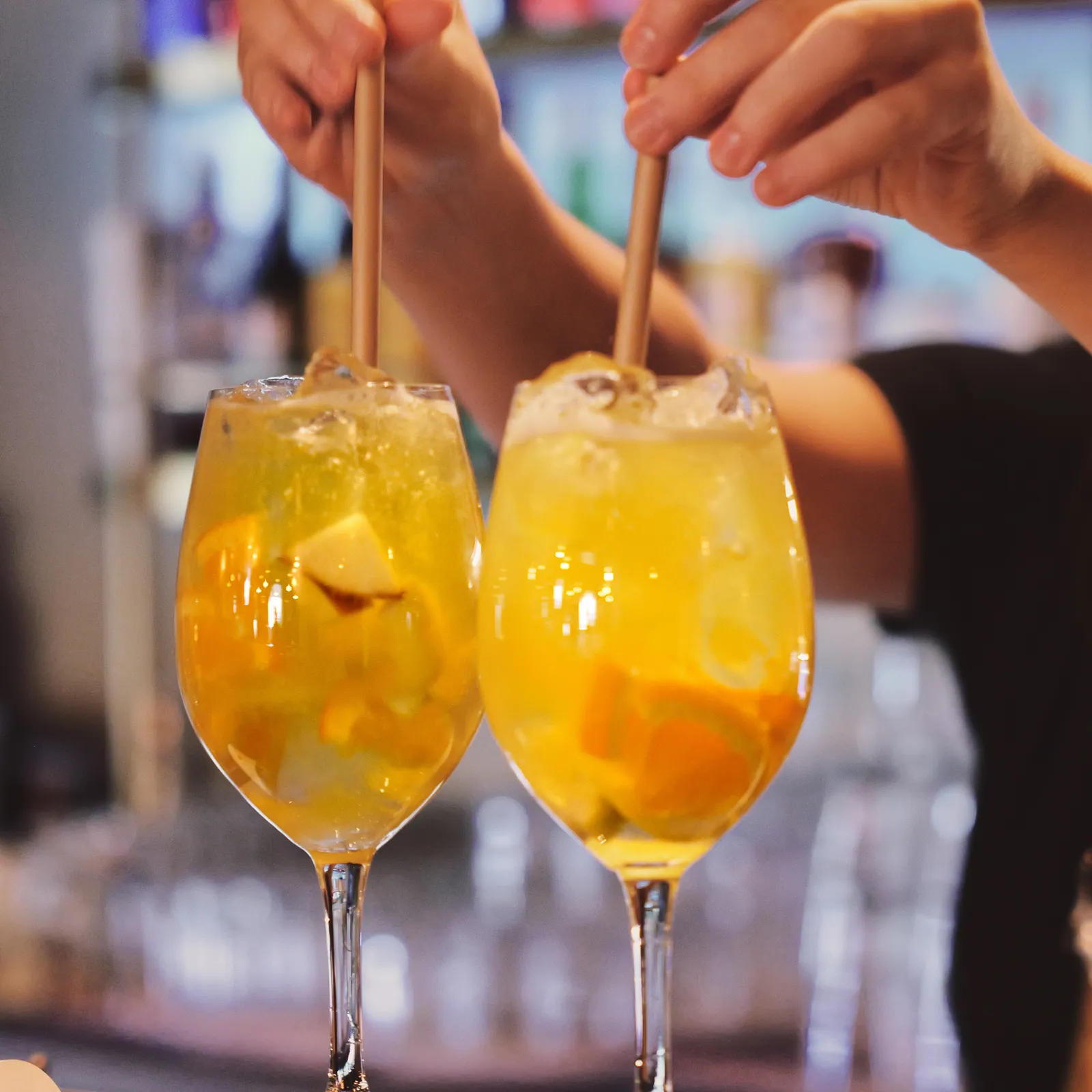 Två gyllene spritzar rörs om i baren
