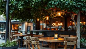 A cozy and inviting scene of an outdoor dining area in Göteborg, Sweden. A classic "boka bord" (reserved table) setup, with a rustic wooden table and chairs nestled under the shade of a lush green canopy. The warm glow of lanterns casts a soft light, creating a welcoming ambiance. In the background, the CALMA restaurant's branding is subtly visible, complementing the natural setting. The scene captures the essence of leisurely dining and the vibrant culinary culture of Göteborg.